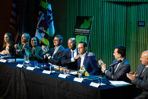 The Executive Council members sit in a long row during their meeting.