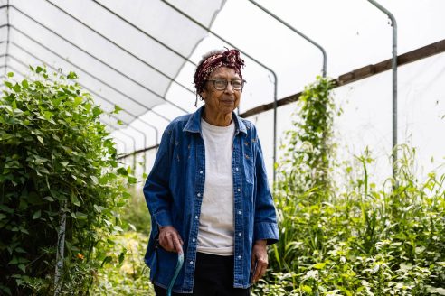 Ira is an elderly Black woman wearing a jean jacket and red bandana.