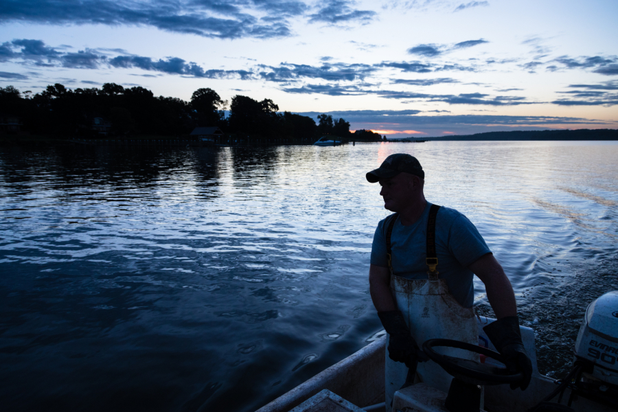 Sunset over water with man on boat