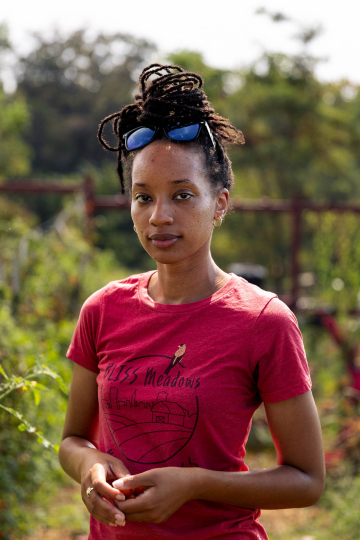 Atiya is a young Black woman wearing a red t-shirt.