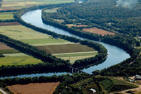 Aerial view of a river weaving through forest and farmland.