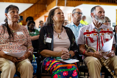 Three members of the Rappahannock Tribe listen intently, watching the speaker during the celebration.