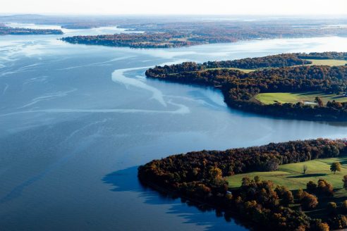 Elk River seen from above showing water and coastline lined with trees.