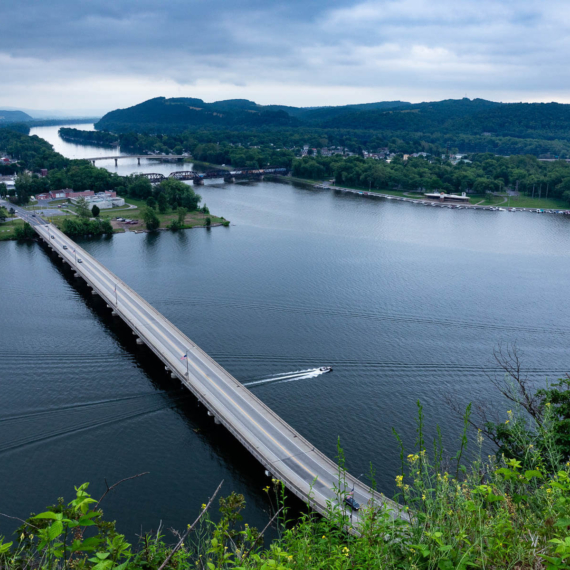 Viewed from a scenic overlook, the rural meeting place of the North and West branches of the Susquehanna River features multiple road and rail bridges.