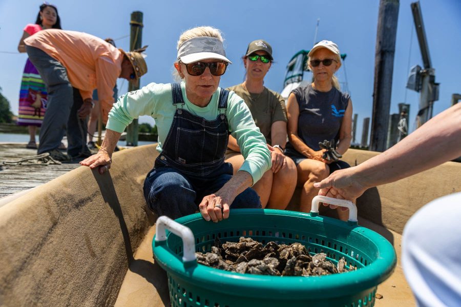 Volunteers on a boat getting ready to drop oysters into the water.