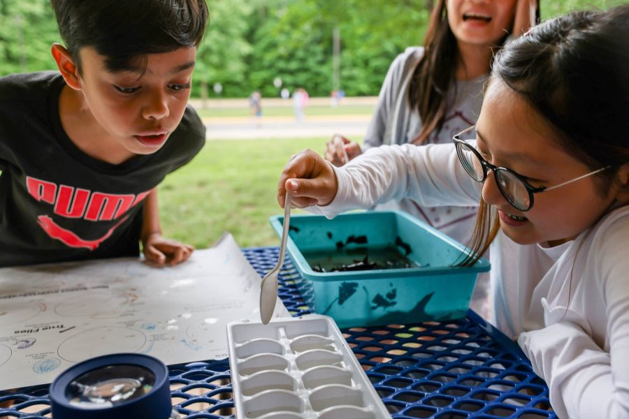 Three kids inspect water samples.