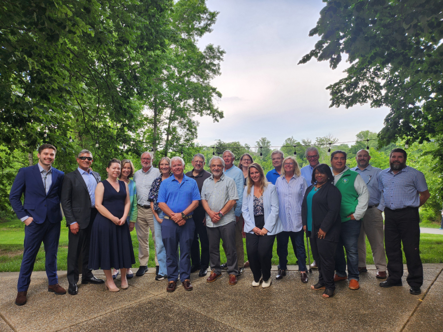 More than a dozen members of the Stakeholders' Advisory Committee stand together smiling.