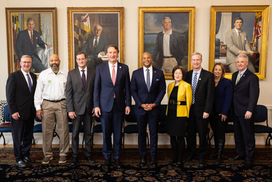 Members of the Chesapeake Executive Council stand in front of paintings of past Maryland governors.