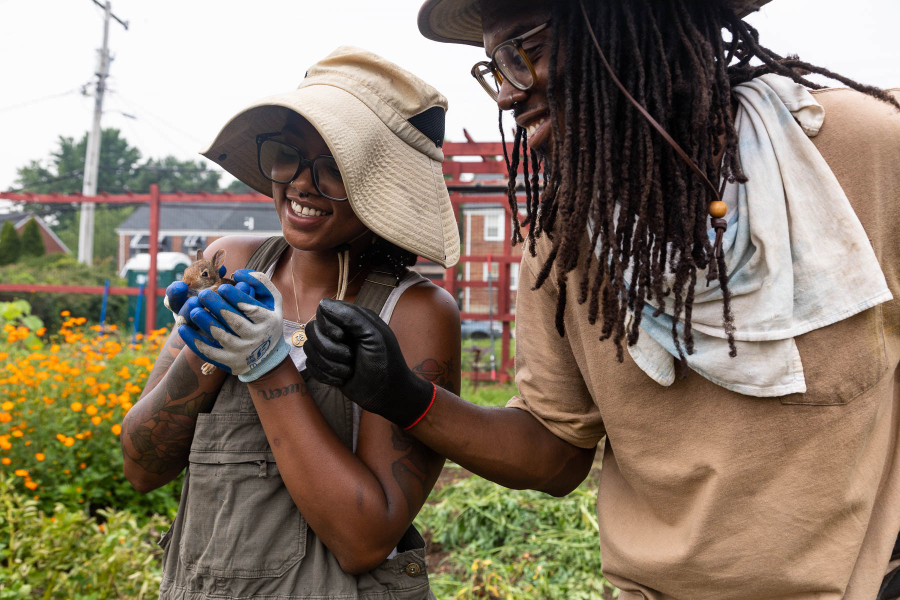 Two young Black farmers standing next to eachother.