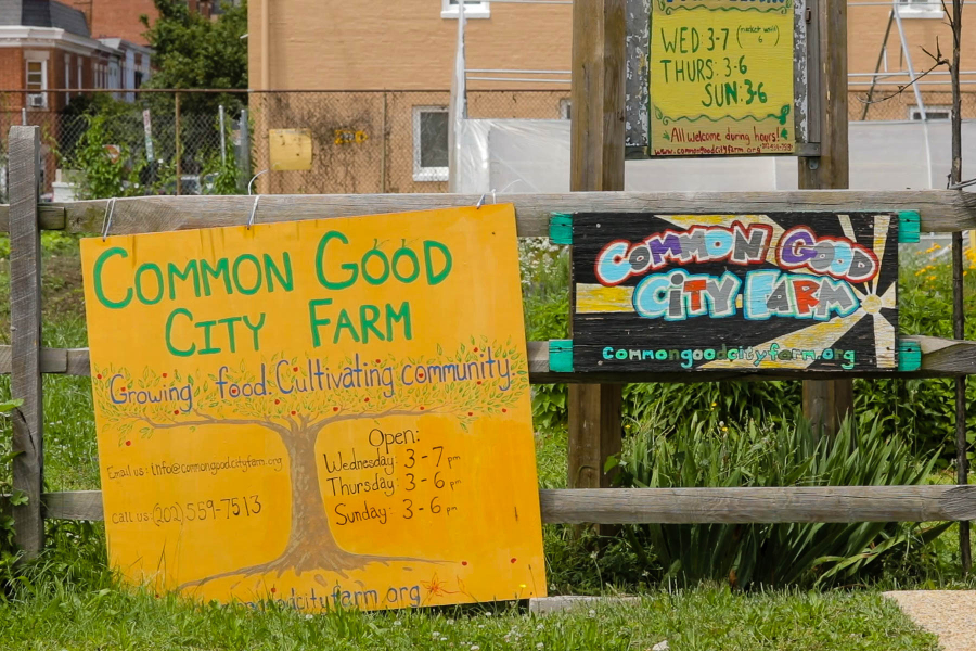 A sign in front of the urban farm that reads Common Good City Farm.