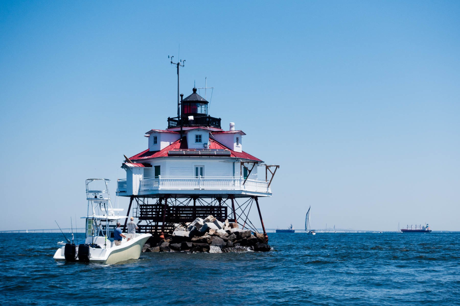 A screw-pile lighthouse on the Bay, set against a blue sky.