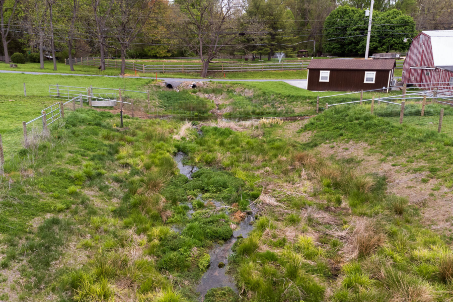 Tributary flows through farmland and a barn.