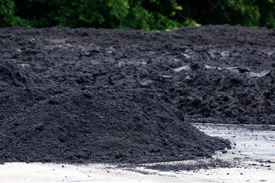 A pile of dark black-grey fertilizer sits outside.