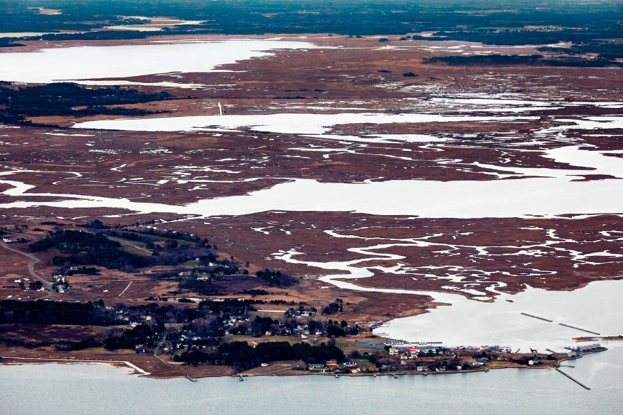 Aerial photograph of a mix of very flat land and water.