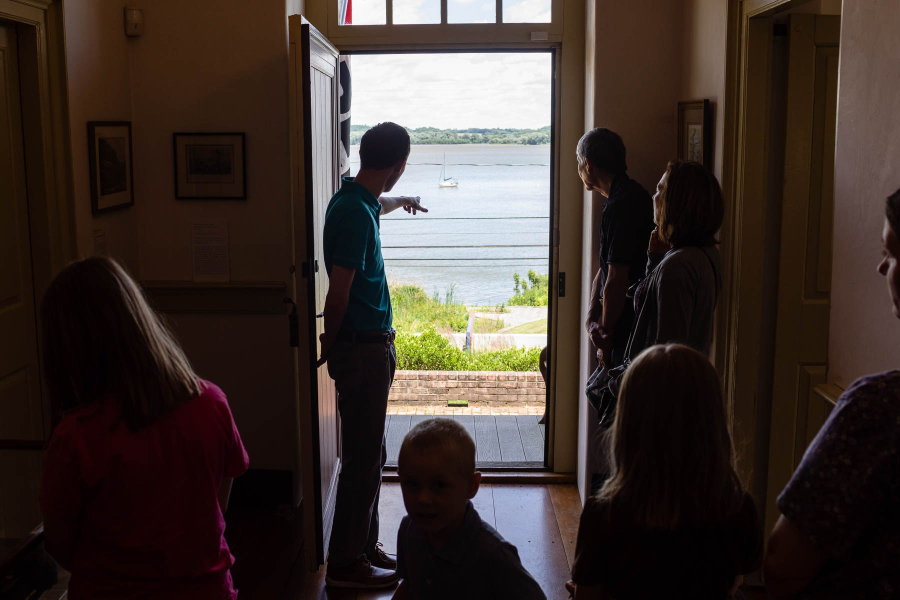 A tour guide points to the river from the open from door of the Zimmerman Center for Heritage.