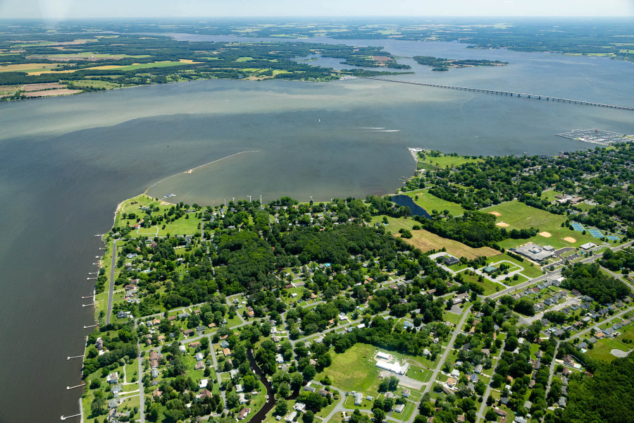 Aerial view of the river with land that includes housing developents and forests.