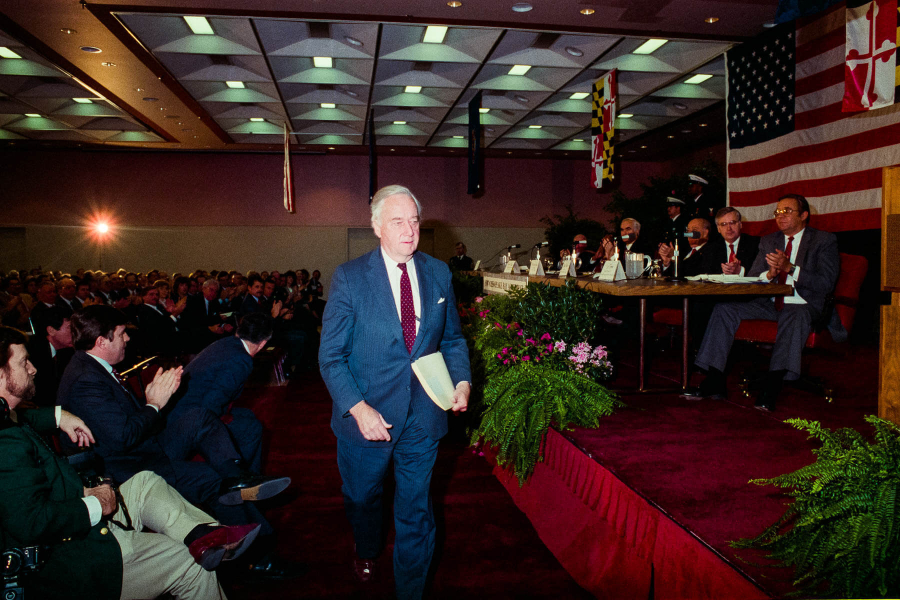 Sen. Mac Mathias walks to the podium during a meeting.