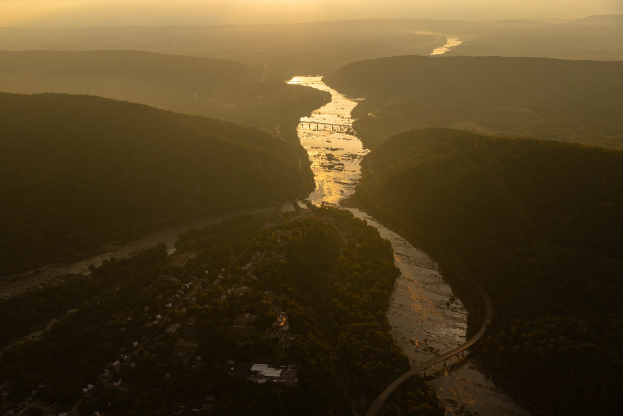 An aerial view of the confluence of two large rivers during a golden sunrise.