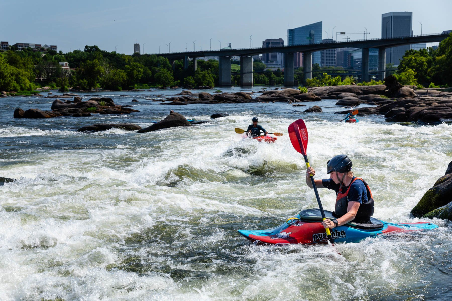 A person white water rafts in a river.