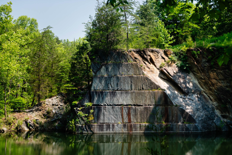 An open face of a mountain showing white-grey rock that was once extracted.