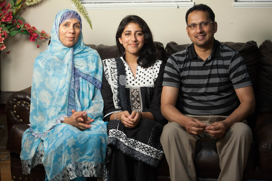 Ailya sitting between her parents.