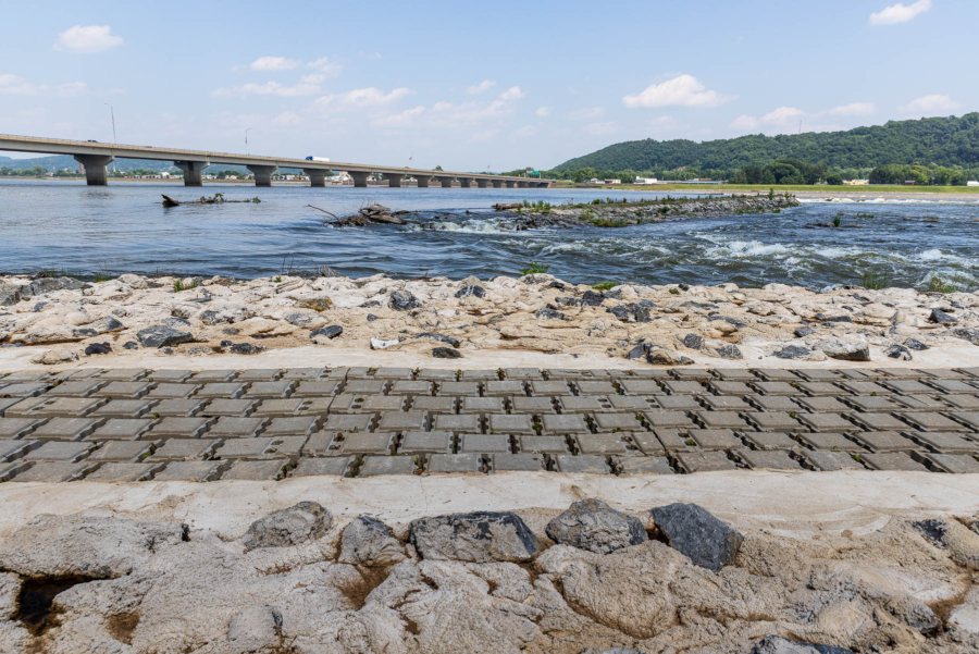 Pervious pavement forms part of a riverbank on the Susquehanna River, with a bridge spanning the river in the distance.