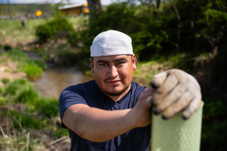 Portrait of Doni Villatoro, crew member, resting on a tree protector.