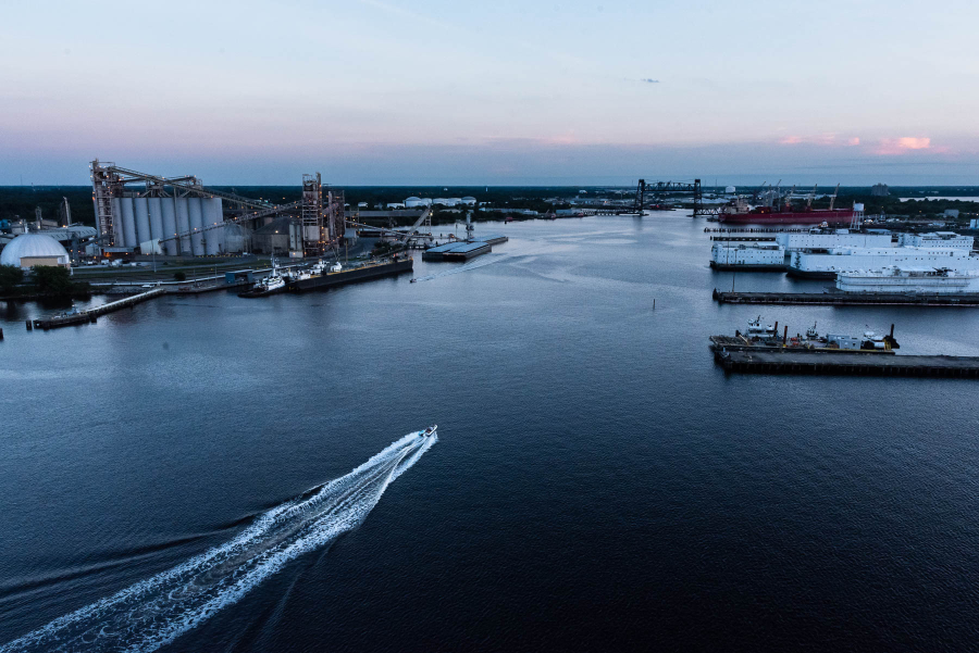 Aerial view of boat traveling down river with ports on both sides