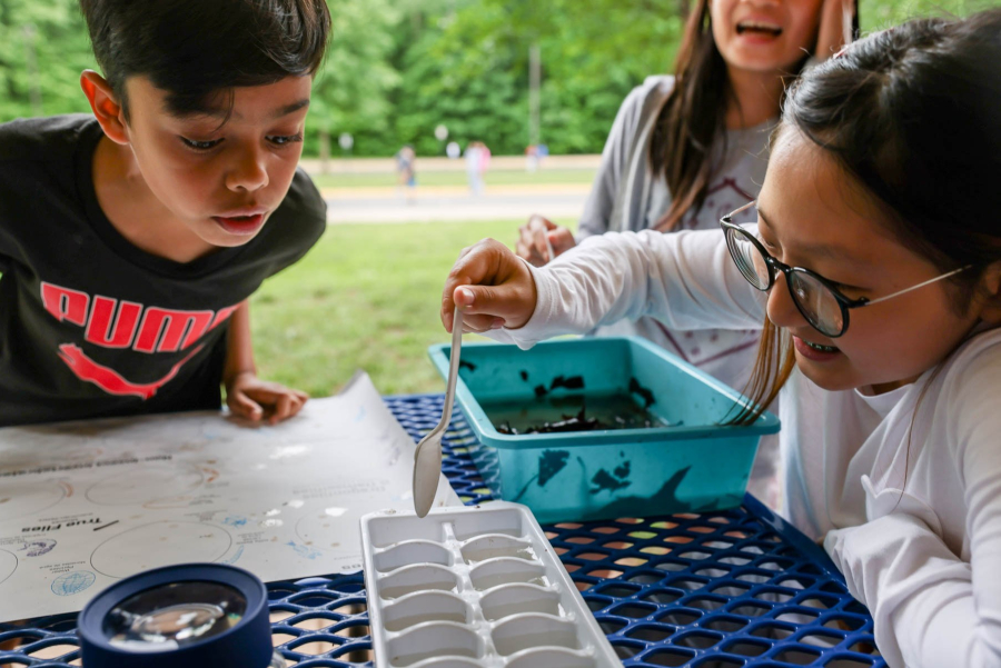 Three kids inspect water samples.