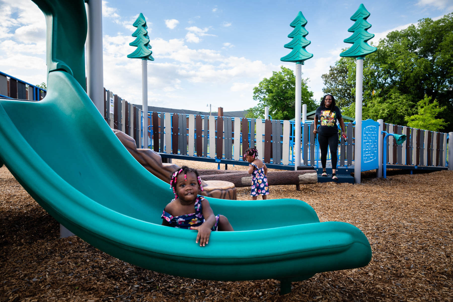 A family enjoys a nature-themed playground at Woodlawn Park in Hopewell