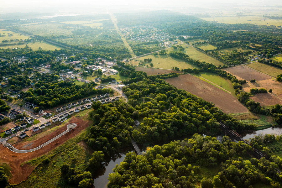 A photo of farm land and forest at a bird's eye view.