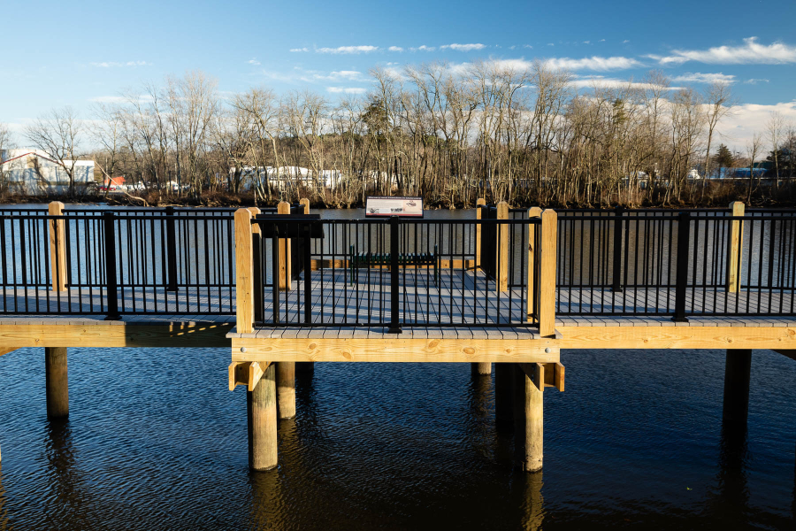 A boardwalk that goes through a river, near the shore.